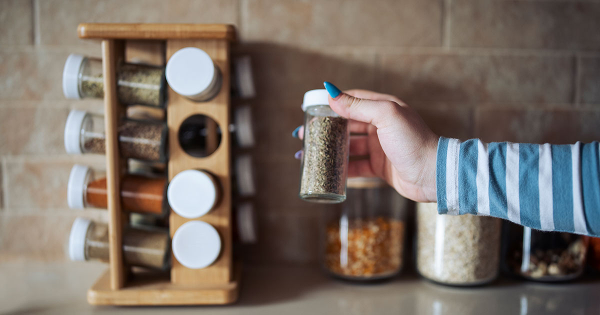 Hand holding bottle of spice.