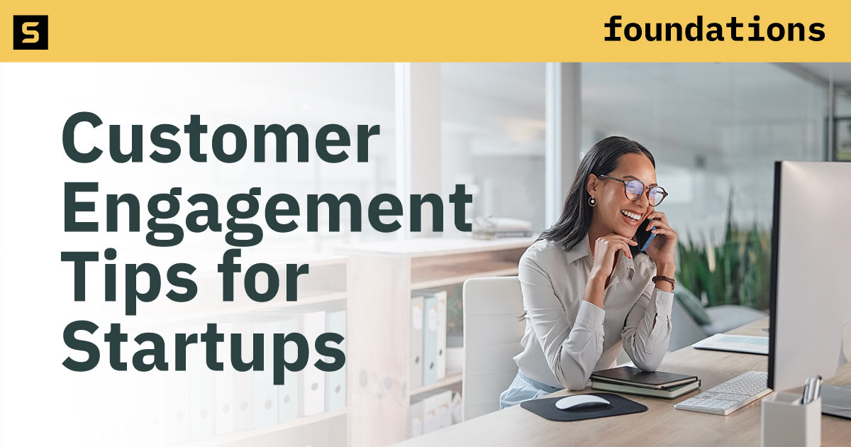 Smiling businesswoman at her computer and on the phone.